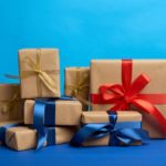 regalos-cajas-envueltas-papel-kraft-marron-atadas-cintas-seda-sobre-fondo-azul_116441-11698