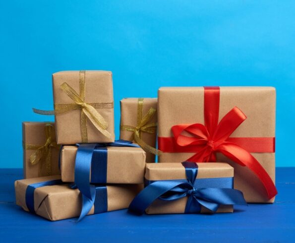 regalos-cajas-envueltas-papel-kraft-marron-atadas-cintas-seda-sobre-fondo-azul_116441-11698